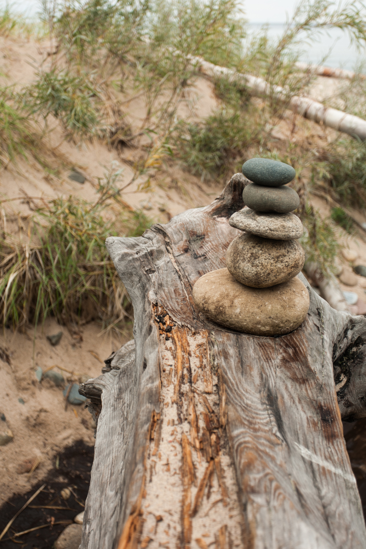 Stacked beach stones on driftwood near the Lake Superior shoreline