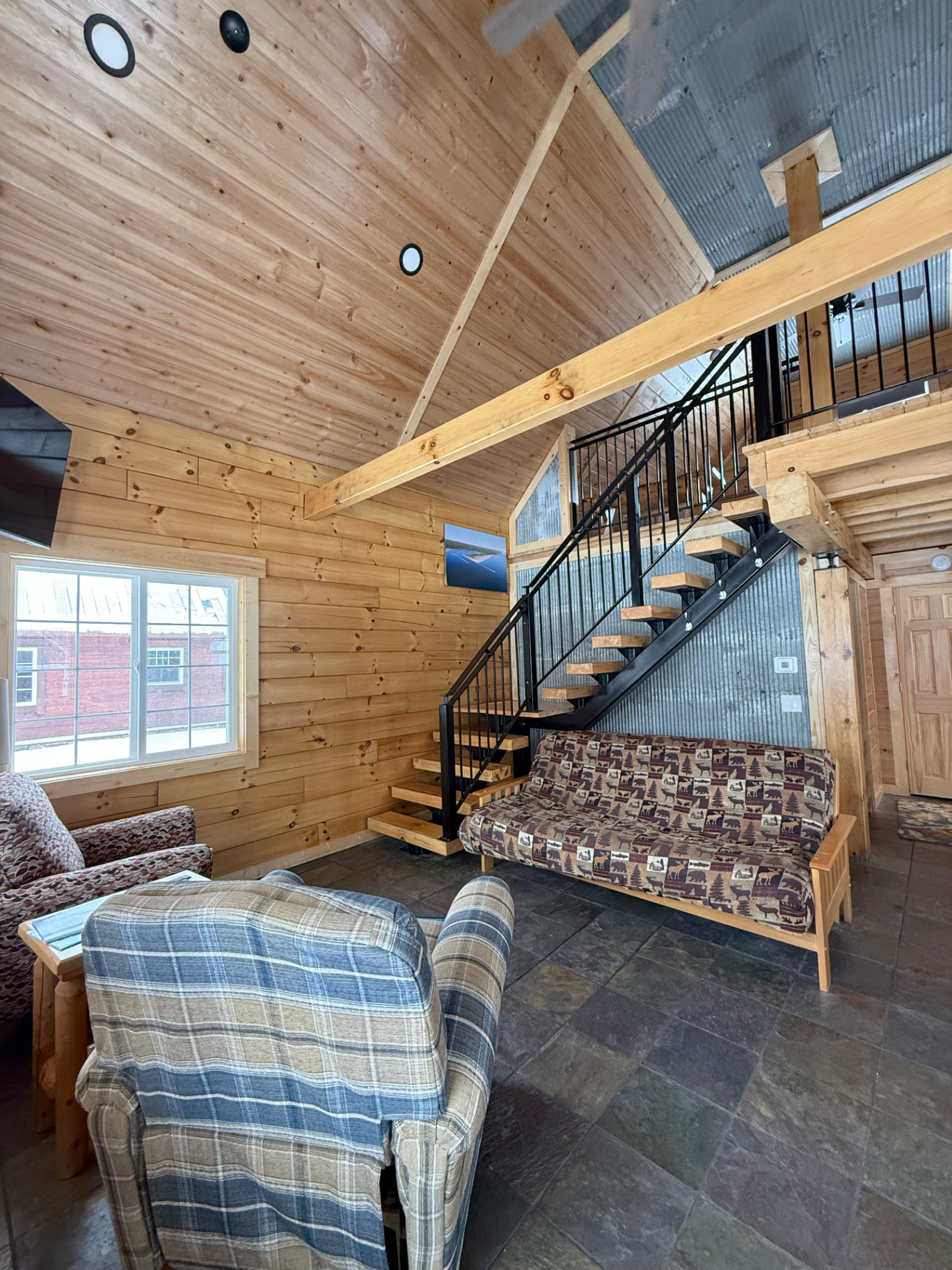 Living room with vaulted ceilings and open staircase