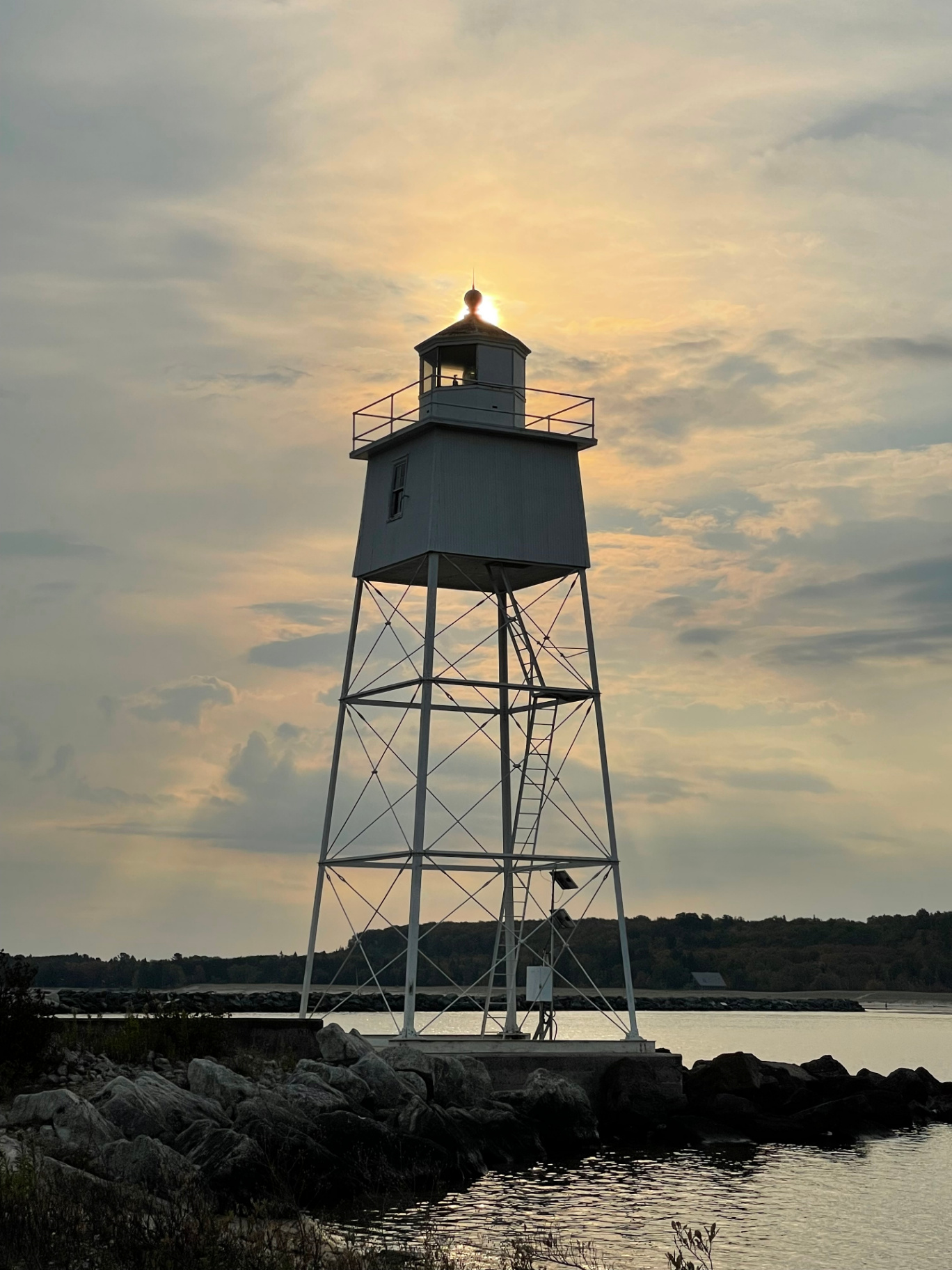 Grand Marais lighthouse silhouetted against a glowing evening sky