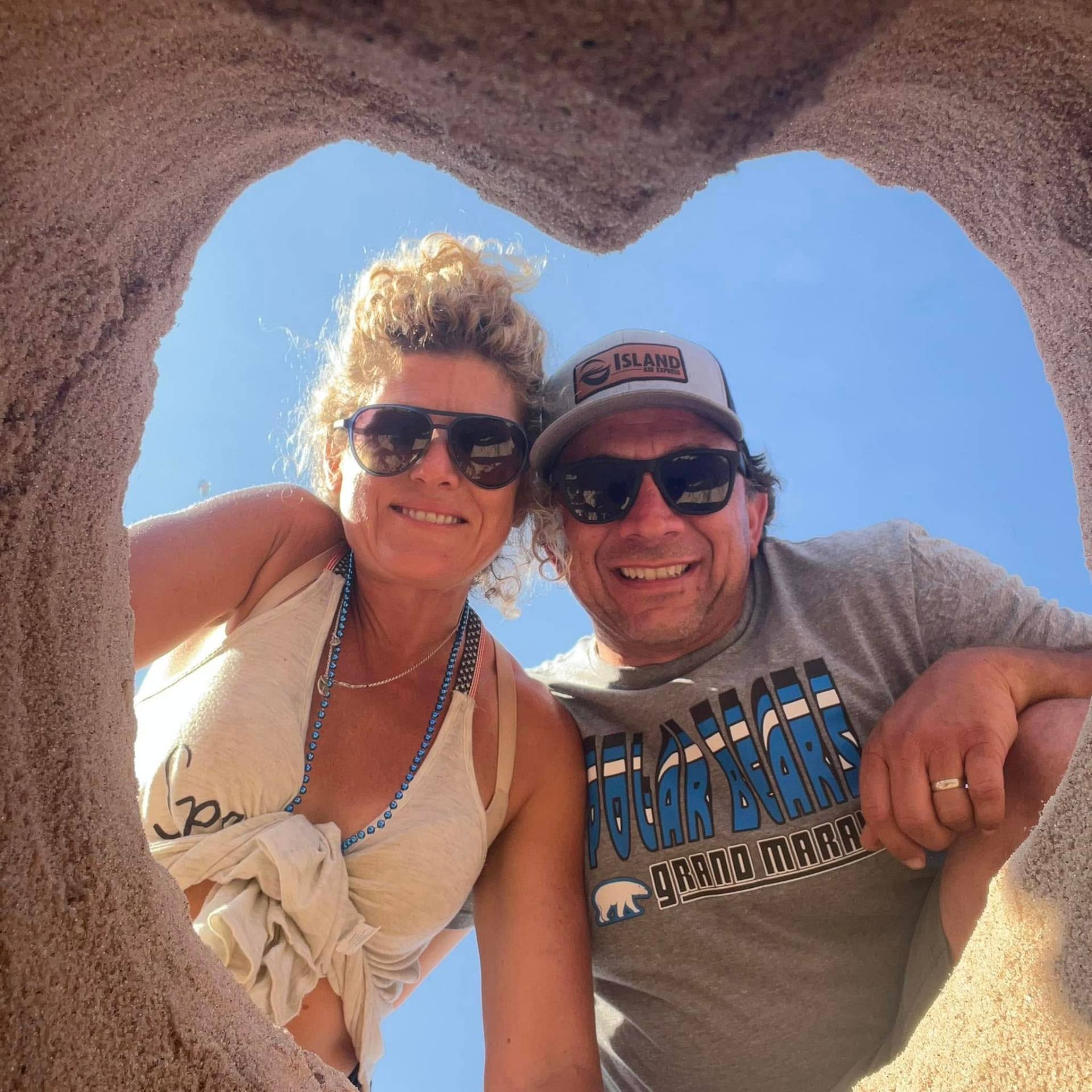 Bonnie and her husband smiling through a stone arch in Grand Marais